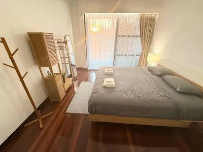 a bedroom with a bed and a window and a ladder at Minimal House Maximum Happiness in Thung Maha Mek