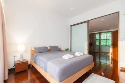a bedroom with a large bed and a large window at Minimal House Maximum Happiness in Thung Maha Mek