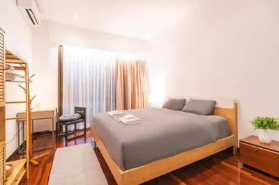 a bedroom with a bed and a desk and a window at Minimal House Maximum Happiness in Thung Maha Mek