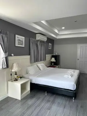 a bedroom with a large white bed and a table at 101Hotel in Bangkok