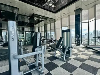 a gym with cardio equipment in a building at Peaceful Stylish and cozy condo in Khlong Toei