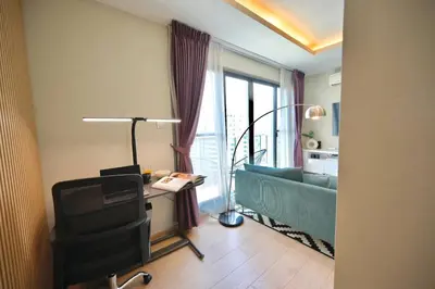 a living room with a couch and a table with a chair at 5min Metro | KingBed | Kitchen full | Netflix WiFi in Khlong Toei