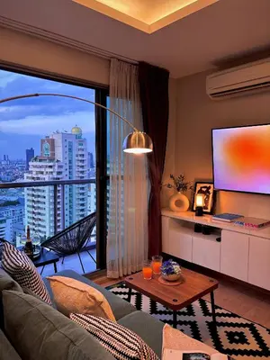 a living room with a couch and a large window at 5min Metro | KingBed | Kitchen full | Netflix WiFi in Khlong Toei