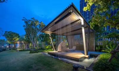 a gazebo in a park with two chairs at The Politan Aqua, River Front in Ban Sai Ma