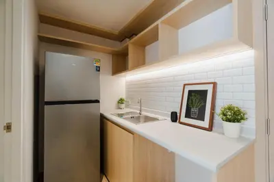 a kitchen with a sink and a refrigerator at I-Zen Residence Central Eastville in Bangkok