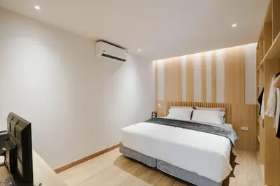 a bedroom with a white bed and a television at I-Zen Residence Central Eastville in Bangkok