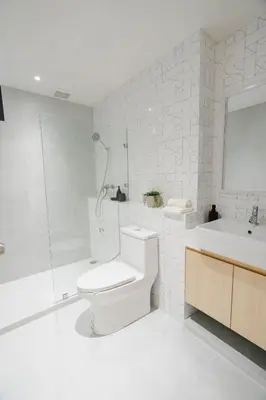 a bathroom with a toilet and a shower and a sink at I-Zen Residence Central Eastville in Bangkok