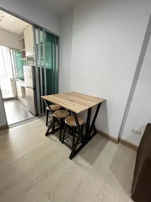 a wooden table and chairs in a room at คอนโดเดอะคิทท์พลัส 113 in Ban Khlong Samrong