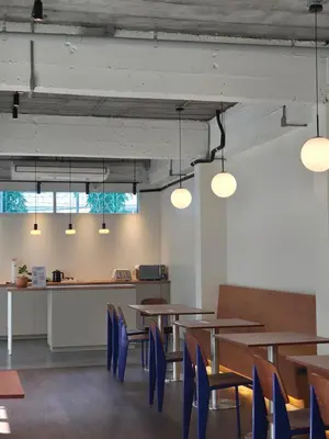 a dining room with wooden tables and blue chairs at Warm Pillow Hotel Bangkok in Bangkok