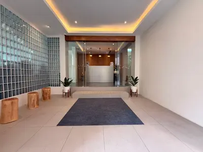 a lobby with a large hallway with a table and benches at Warm Pillow Hotel Bangkok in Bangkok