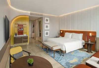 a hotel room with a bed and a living room at Andaz One Bangkok in Bangkok