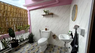 a bathroom with a toilet and a sink on a balcony at Baan YentaFo - Pink House in Talad Noi in Chinatown