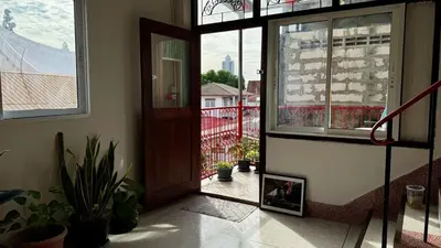 an open door to a balcony with potted plants at Baan PadSeeEw - Rooftop Riverview in Khlong San