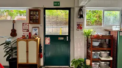 a green door with a window in a kitchen at Baan PadSeeEw - Rooftop Riverview in Khlong San