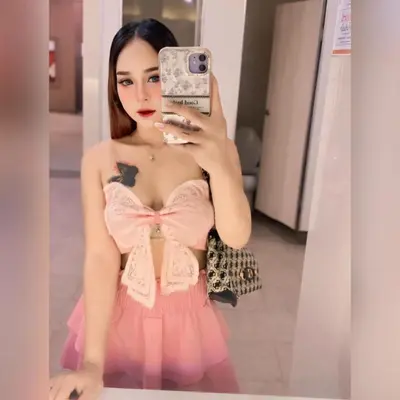 a girl in a pink dress taking a picture with her cell phone at Noey sun in Sathani Sam Sen