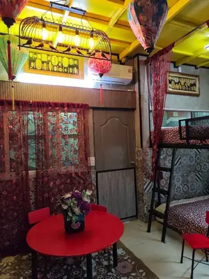 a room with a red table with a vase of flowers on it at โรงแรม เลิฟ บีเคเค in Amphoe Phra Khanong
