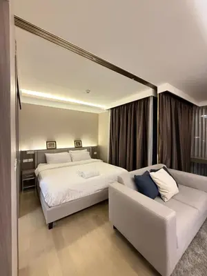 a bedroom with a large bed and a couch at Cozy room in Sukumvit in Bangkok