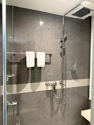 a bathroom with a shower with two white towels at Cozy room in Sukumvit in Bangkok