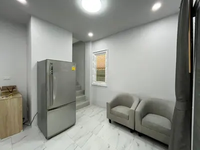 a kitchen with a stainless steel refrigerator and two chairs at Cozy Corner in Samut Prakan