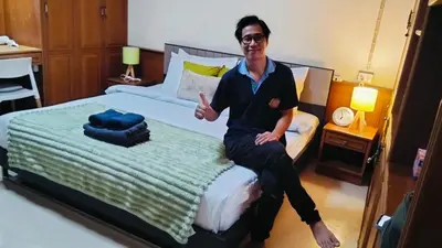 a man sitting on a bed in a room at Old Town cozy corner in Thonhuri