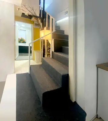 a staircase in a house with a yellow wall at AkkHouse in Ban Bang Toei (1)