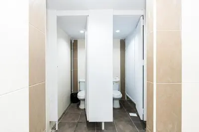 a bathroom with two toilets and two sinks at XX The Hidden Khaosan Road Bangkok in Bang Bua Thong Railway Station