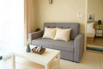 a living room with a couch and a table at Executive 1 BR and Sofa bed Next to T21 Asoke BTS in Bangkok