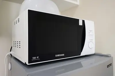a white microwave oven sitting on top of a counter at Executive 1 BR and Sofa bed Next to T21 Asoke BTS in Bangkok