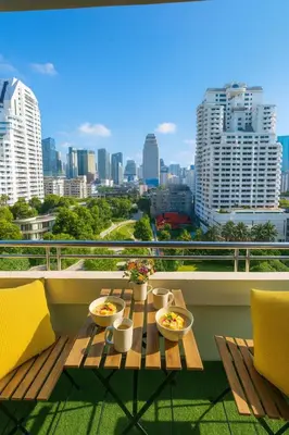 a table on a balcony with a view of a city at Modern 2 Bed Executive Unit 5min to Nana BTS in Bangkok