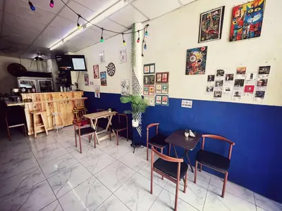 a restaurant with tables and chairs and a blue wall at Happy Hope Khao San in Bangkok