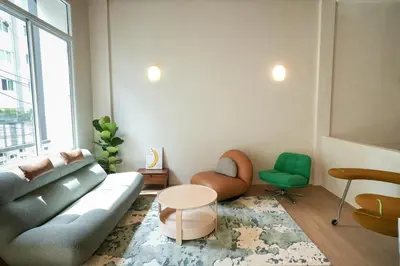 a living room with a couch and a table at day one space - BTS On Nut - Live Above Cowork Cafe in Bangkok
