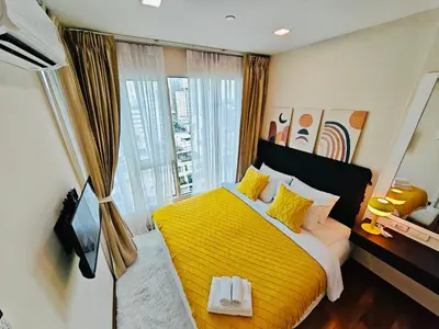 a bedroom with a yellow bed and a large window at Downtown, Cozy 1BR, 48sqm, Middle of ThongLo, High Floor, Pool, Gym, Fast Wifi in Bangkok