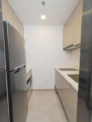 a kitchen with a stainless steel refrigerator and white cabinets at KINGbed with Pool Gym and Standing Desk near MRT in Bangkok