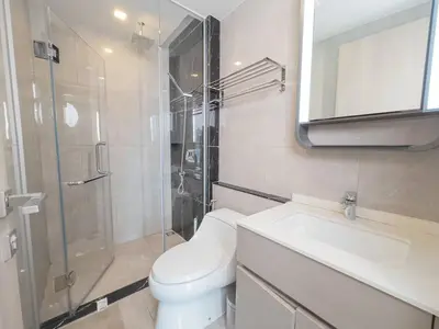 a bathroom with a toilet and a sink and a shower at KINGbed with Pool Gym and Standing Desk near MRT in Bangkok