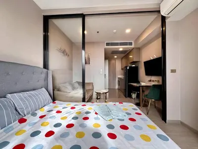 a bedroom with a bed with a polka dot blanket at 52nd Fl Apt with Desk Pool and Gym MRT 200m Away in Ban Na Song