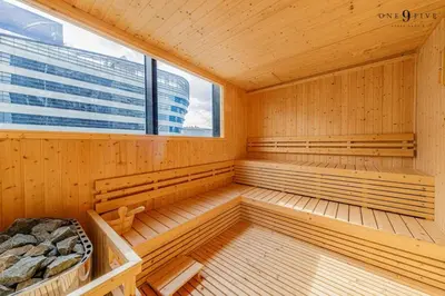 a sauna with wooden benches and a large window at 52nd Fl Apt with Desk Pool and Gym MRT 200m Away in Ban Na Song