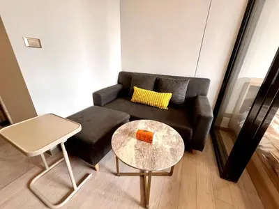 a living room with a couch and a table at Free Parking with Balcony Pool and Gym MRT 200m in Ban Na Song