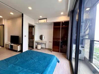 a bedroom with a blue bed and a large window at High Floor Apt with Large Living Room Pool and Gym in Ban Na Song