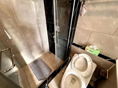 a small bathroom with a toilet and a shower at King Bed with Living Room Pool and Gym MRT 200m in Ban Na Song