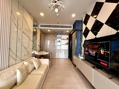 a living room with a couch and a tv at 53Fl Skyview with King Bed Pool and Gym MRT200m in Ban Na Song