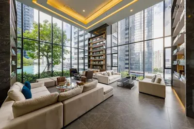 a living room with a large couch and large windows at 53Fl Skyview with King Bed Pool and Gym MRT200m in Ban Na Song
