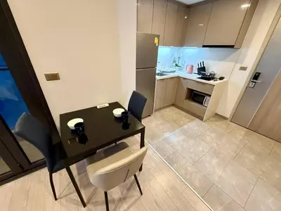 a small kitchen with a table and chairs in a room at Peak Luxury Living with King Bed Golf Pool and Gym in Ban Na Song
