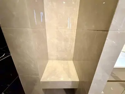 a beige tiled wall with a shelf on it at Peak Luxury Living with King Bed Golf Pool and Gym in Ban Na Song