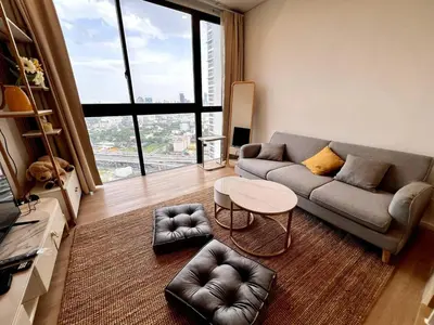 a living room with a couch and a table at High Floor Loft with Pool and Gym in Ban Na Song