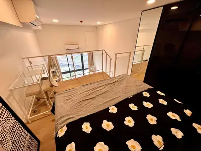 a bedroom with a bed with flowers on it at High Floor Loft with Pool and Gym in Ban Na Song
