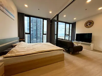 a bedroom with a large bed and a television at Spacious Apt with King Bed Pool and Gym MRT200m in Bangkok