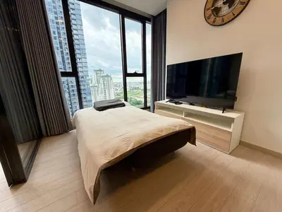 a bedroom with a large bed and a large television at Spacious Apt with King Bed Pool and Gym MRT200m in Bangkok