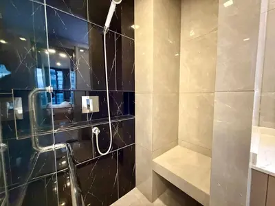 a bathroom with a shower with a glass wall at Spacious Apt with King Bed Pool and Gym MRT200m in Bangkok