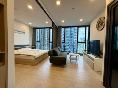 a bedroom with a bed and a couch and a television at Spacious Apt with King Bed Pool and Gym MRT200m in Bangkok