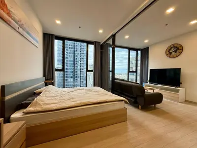 a bedroom with a large bed and a television at Spacious Apt with King Bed Pool and Gym MRT200m in Bangkok